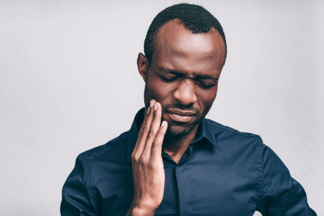 dental-patient-with-tooth-pain 2 Patient Suffering From Dental Implant Failures