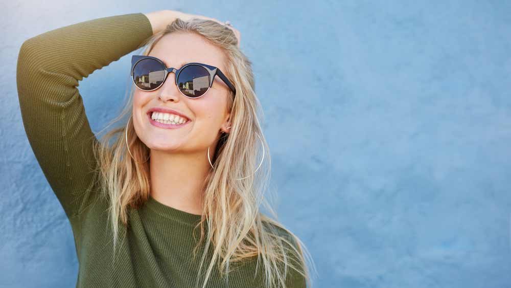 a dental patient smiling after her porcelain veneers procedure
