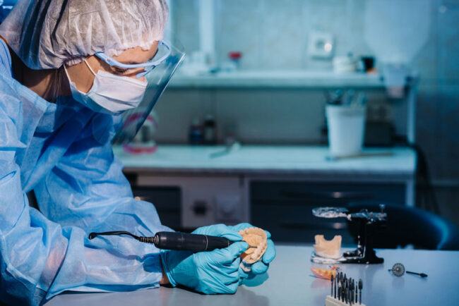 prosthedontist-milling-implant-model a dental implant dentist milling a full mouth dental implant prosthetic in a dental lab.