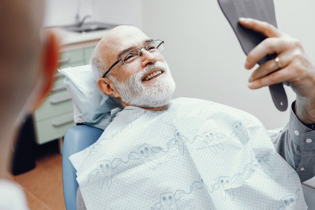 man-sitting-in-a-dentist-chair-smiling An image of an older man sitting in a dentist chair and smiling.