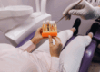 Patient in chair holding a dental implant model with thew doctor giving information